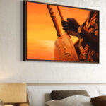 Tableau représentant les mains d’un joueur de kora sur fond orangé, vue en perspective au-dessus d’un lit