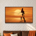 Tableau Rêverie au couchant aux tons orange et or, mis en scène au-dessus d’un canapé marron
